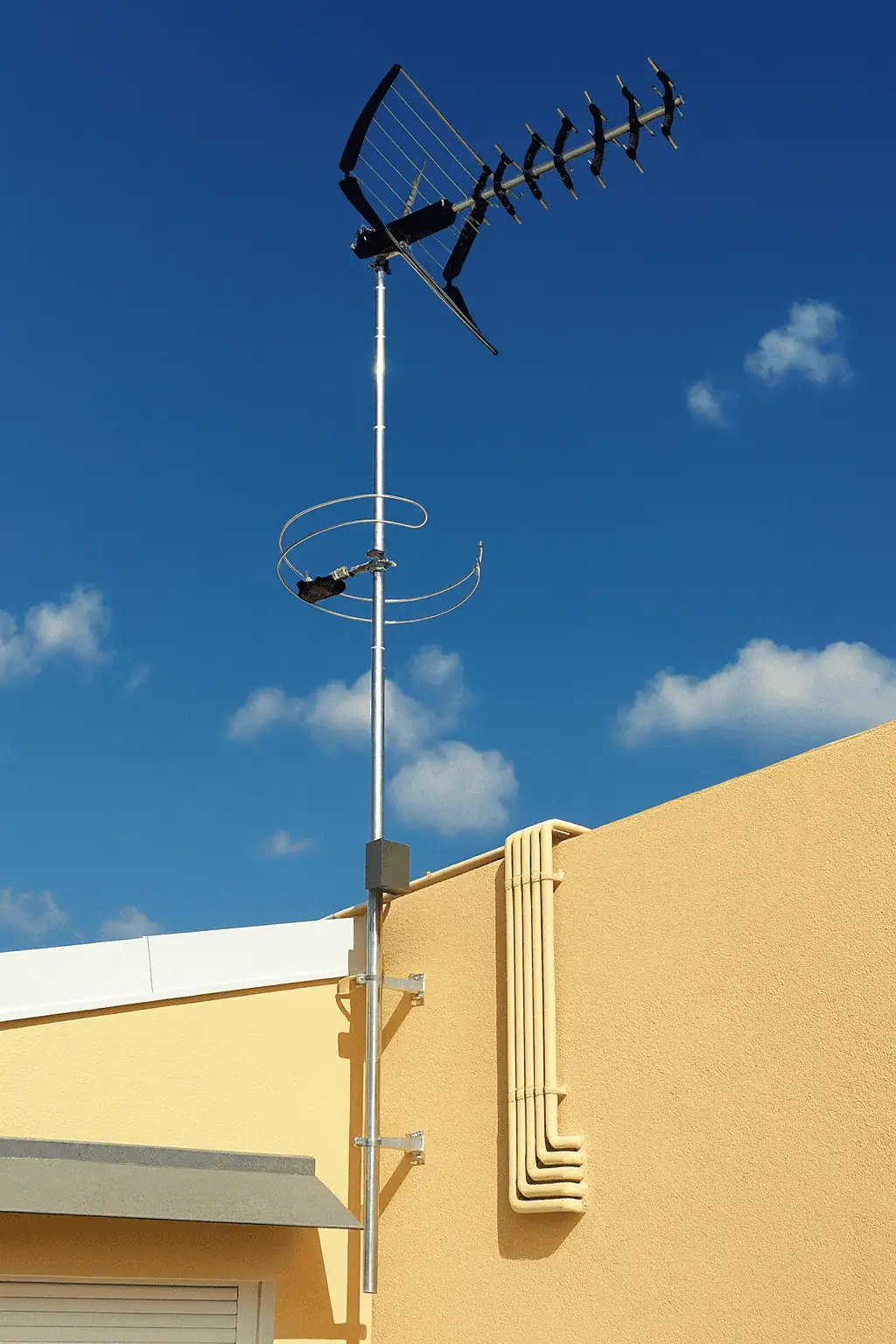 Instalador de antena TDT ajustando la señal en un tejado